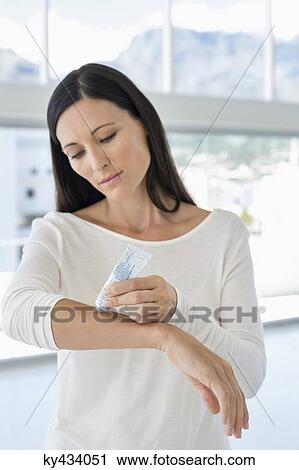 Woman applying ointment on her arm View Large Photo Image Stock Image - Woman applying ointment on her arm. Fotosearch