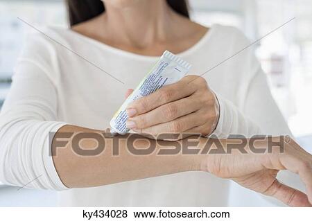 Woman applying ointment on her arm View Large Photo Image Stock Photo - Woman applying ointment on her arm. Fotosearch