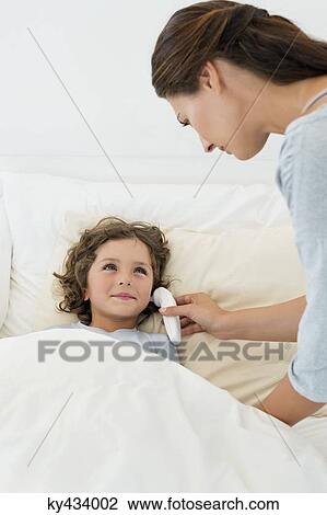 Woman checking fever of her son with a thermometer View Large Photo Image Stock Image - Woman checking fever of her son with a thermometer. Fotosearch