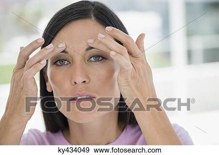Woman checking wrinkles on her face View Large Photo Image Stock Photo - Woman checking wrinkles on her face. Fotosearch