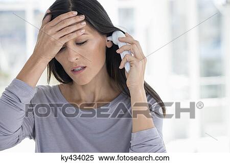 Woman measuring her temperature with a digital thermometer View Large Photo Image Stock Photography - Woman measuring her temperature with a digital thermometer. Fotosearch