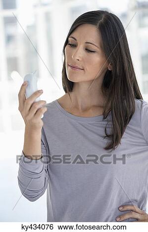 Woman reading a digital thermometer View Large Photo Image Stock Photograph - Woman reading a digital thermometer. Fotosearch
