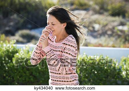 Woman sneezing while smelling a flower View Large Photo Image Stock Image - Woman sneezing while smelling a flower. Fotosearch