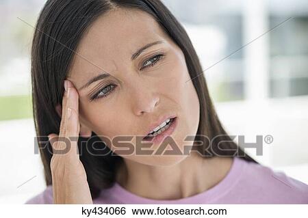 Woman suffering from a headache View Large Photo Image Stock Photograph - Woman suffering from a headache. Fotosearch