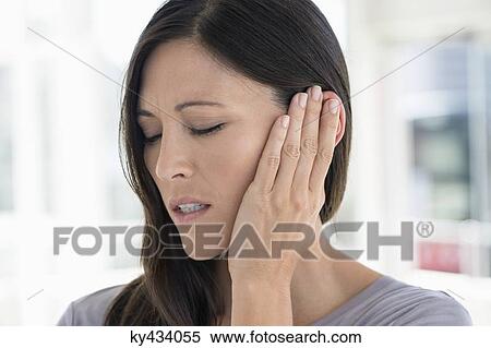 Woman suffering from an ear ache View Large Photo Image Stock Photography - Woman suffering from an ear ache. Fotosearch