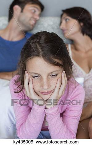 Close-up of a girl thinking with her parents discussing in the background View Large Photo Image Stock Photography - Close-up of a girl thinking with her parents discussing in the background. Fotosearch