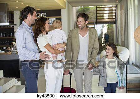 Couple looking at their friend arriving from holiday View Large Photo Image Stock Image - Couple looking at their friend arriving from holiday. Fotosearch