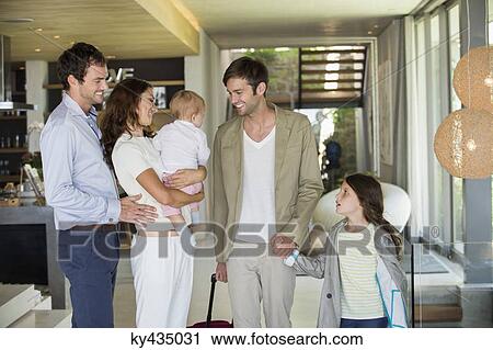 Couple looking at their friend arriving from holiday View Large Photo Image Stock Image - Couple looking at their friend arriving from holiday. Fotosearch
