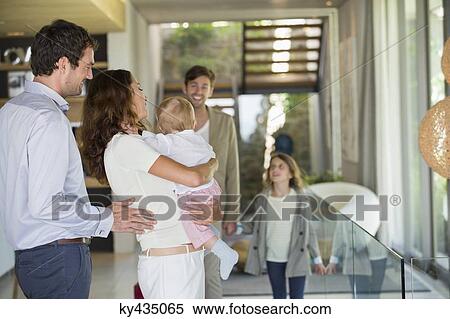 Couple looking at their friend arriving from holiday View Large Photo Image Stock Photography - Couple looking at their friend arriving from holiday. Fotosearch