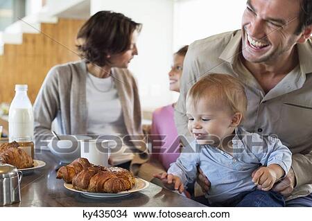 Family having breakfast at a kitchen counter View Large Photo Image Picture - Family having breakfast at a kitchen counter. Fotosearch