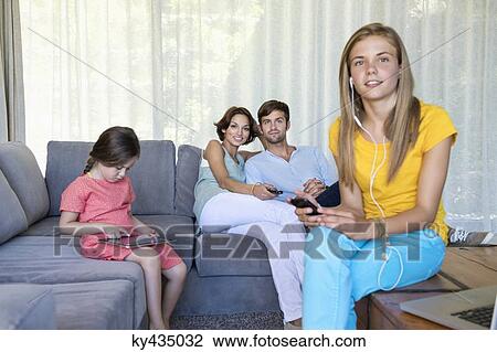 Family in a living room View Large Photo Image Stock Image - Family in a living room. Fotosearch