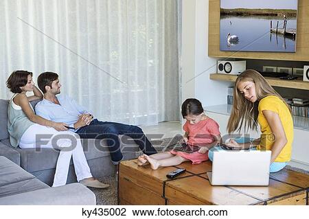 Family using electronics gadgets View Large Photo Image Stock Image - Family using electronics gadgets. Fotosearch