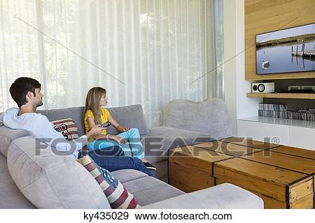 Father watching television with his daughter View Large Photo Image Stock Photo - Father watching television with his daughter. Fotosearch