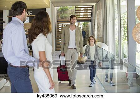 Stock Photo - Man with his daughter arriving at his friends home from holiday. Fotosearch