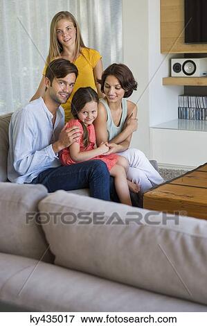 Parents with their children sitting in a living room View Large Photo Image Stock Photo - Parents with their children sitting in a living room. Fotosearch