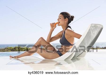 Beautiful woman eating a slice of papaya View Large Photo Image Stock Photo - Beautiful woman eating a slice of papaya. Fotosearch