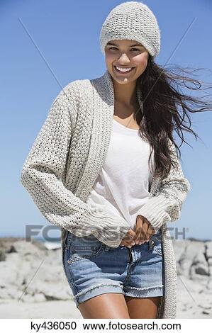 Stock Image - Beautiful woman enjoying on the beach in winter. Fotosearch