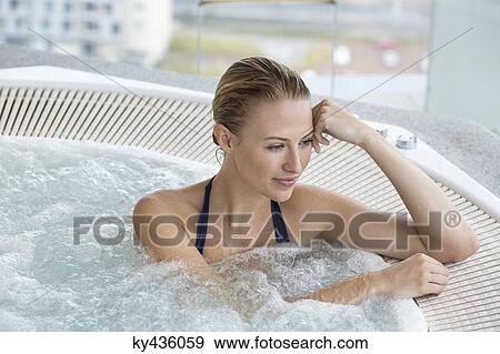 Stock Photo - Beautiful woman in a hot tub. Fotosearch