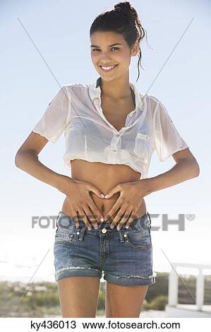 Beautiful woman making heart shape with hands on belly View Large Photo Image Stock Image - Beautiful woman making heart shape with hands on belly. Fotosearch