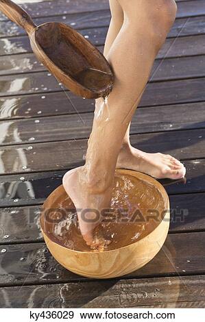 Stock Photo - Low section view of a woman washing her leg on the beach. Fotosearch