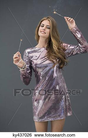 Portrait of a woman celebrating with sparkler and smiling View Large Photo Image Stock Photograph - Portrait of a woman celebrating with sparkler and smiling. Fotosearch