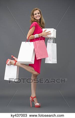 Portrait of a woman posing with shopping bags and smiling View Large Photo Image Stock Image - Portrait of a woman posing with shopping bags and smiling. Fotosearch