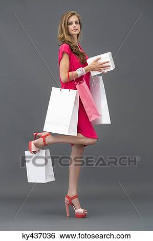 Portrait of a woman posing with shopping bags View Large Photo Image Stock Photograph - Portrait of a woman posing with shopping bags. Fotosearch