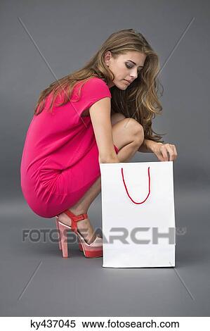 Woman searching into a shopping bag View Large Photo Image Stock Photography - Woman searching into a shopping bag. Fotosearch