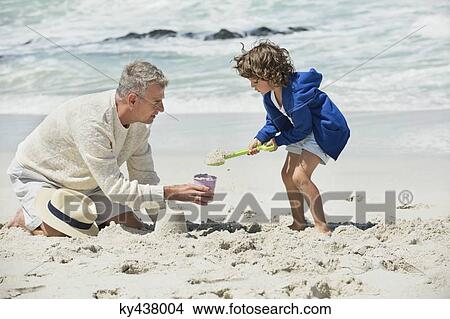 Boy playing with his grandfather on the beach View Large Photo Image Picture - Boy playing with his grandfather on the beach. Fotosearch