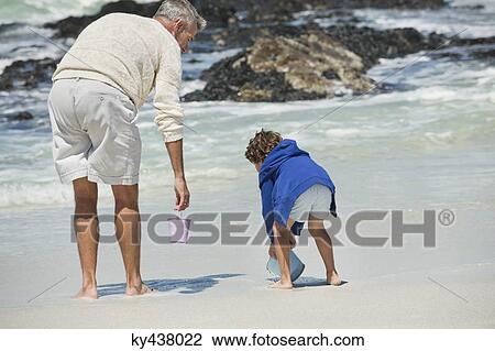 Boy playing with his grandfather on the beach View Large Photo Image Stock Image - Boy playing with his grandfather on the beach. Fotosearch