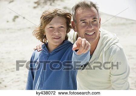 Boy pointing with his grandfather on the beach View Large Photo Image Stock Image - Boy pointing with his grandfather on the beach. Fotosearch