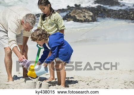 Children playing with their grandfather on the beach View Large Photo Image Stock Photography - Children playing with their grandfather on the beach. Fotosearch