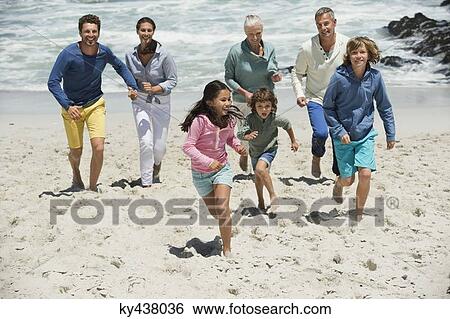 Stock Photograph - Family running on the beach. Fotosearch