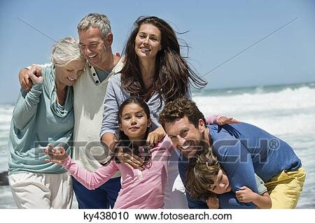 Stock Image - Family smiling on the beach. Fotosearch