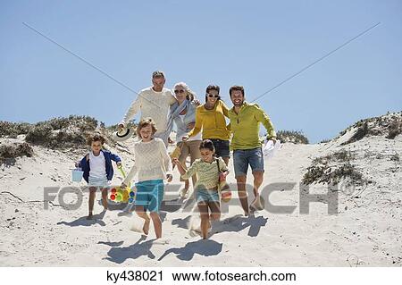 Stock Image - Family walking on the beach. Fotosearch