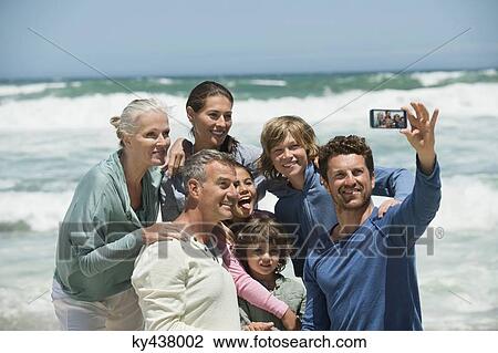Happy multi-generation family taking a self portrait with a cell phone on the beach View Large Photo Image Stock Image - Happy multi-generation family taking a self portrait with a cell phone on the beach. Fotosearch