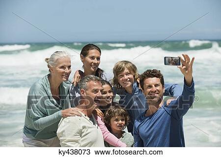 Happy multi-generation family taking a self portrait with a cell phone on the beach View Large Photo Image Stock Image - Happy multi-generation family taking a self portrait with a cell phone on the beach. Fotosearch
