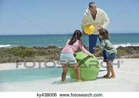 Man playing with his grandchildren on the beach View Large Photo Image Stock Photograph - Man playing with his grandchildren on the beach. Fotosearch