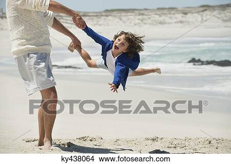 Man playing with his grandson on the beach View Large Photo Image Picture - Man playing with his grandson on the beach. Fotosearch