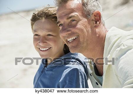 Man smiling with his grandson on the beach View Large Photo Image Stock Photo - Man smiling with his grandson on the beach. Fotosearch