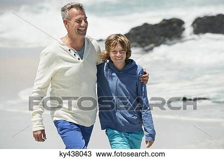 Man walking with his grandson on the beach View Large Photo Image Stock Image - Man walking with his grandson on the beach. Fotosearch