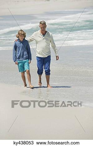 Man walking with his grandson on the beach View Large Photo Image Stock Image - Man walking with his grandson on the beach. Fotosearch
