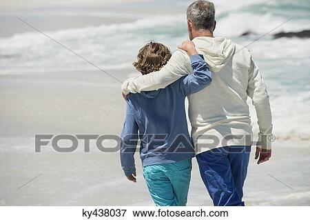 Man walking with his grandson on the beach View Large Photo Image Stock Photo - Man walking with his grandson on the beach. Fotosearch