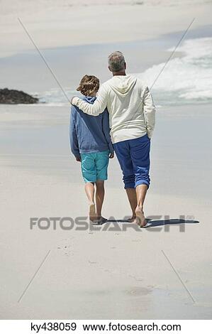 Man walking with his grandson on the beach View Large Photo Image Stock Photo - Man walking with his grandson on the beach. Fotosearch