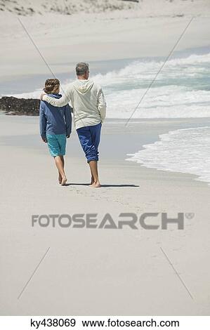 Man walking with his grandson on the beach View Large Photo Image Stock Photo - Man walking with his grandson on the beach. Fotosearch