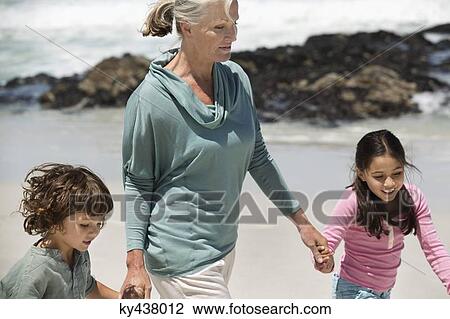 Woman playing with her grandchildren on the beach View Large Photo Image Stock Image - Woman playing with her grandchildren on the beach. Fotosearch