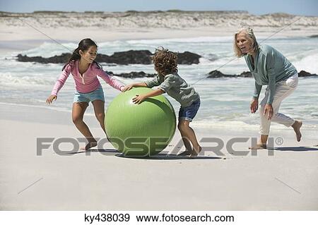Woman playing with her grandchildren on the beach View Large Photo Image Stock Photo - Woman playing with her grandchildren on the beach. Fotosearch