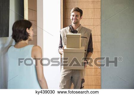 Delivery man delivering parcel to a woman View Large Photo Image Stock Image - Delivery man delivering parcel to a woman. Fotosearch