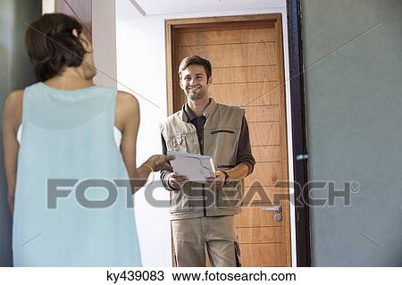 Delivery man delivering parcel to a woman View Large Photo Image Stock Image - Delivery man delivering parcel to a woman. Fotosearch