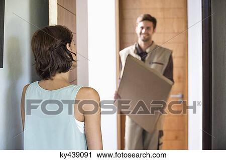 Delivery man delivering parcel to a woman View Large Photo Image Stock Image - Delivery man delivering parcel to a woman. Fotosearch